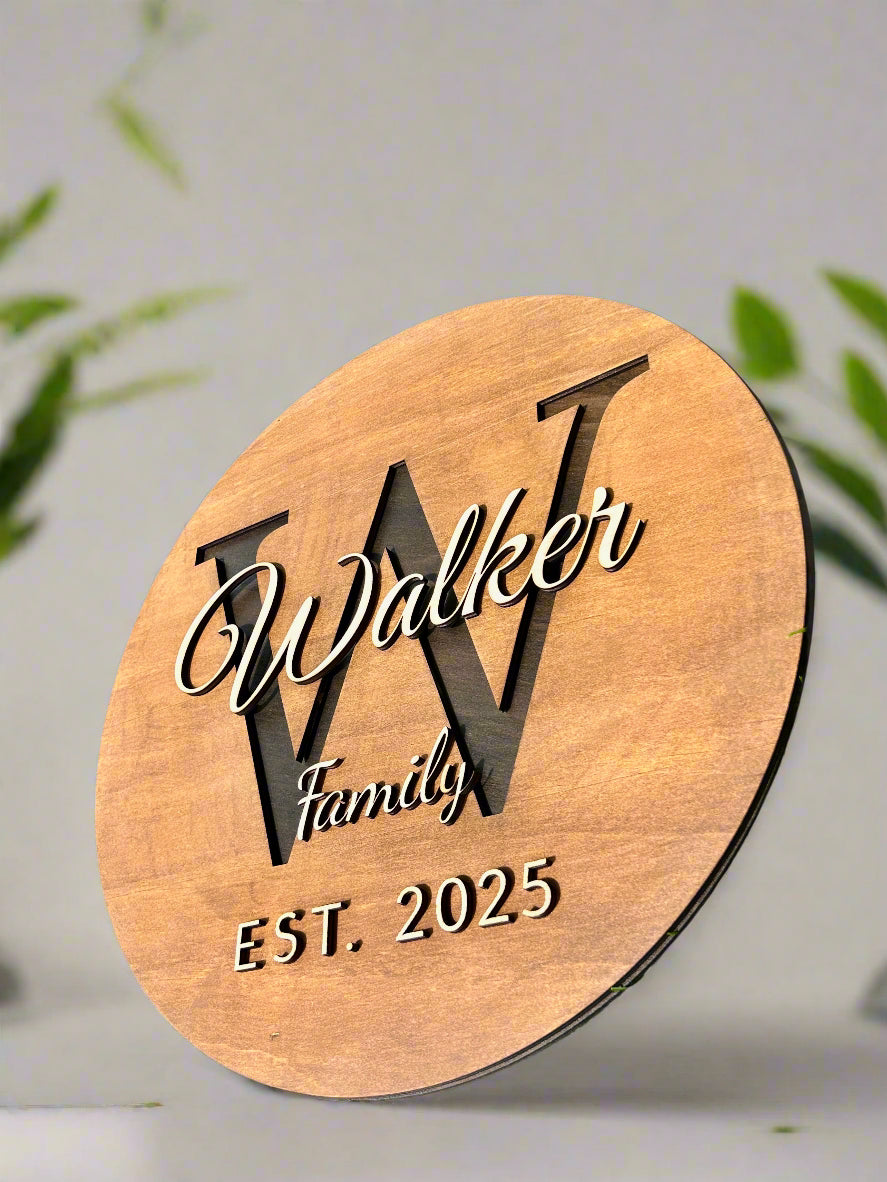 Wooden plaque with 'Walker Family EST. 2025' on grass